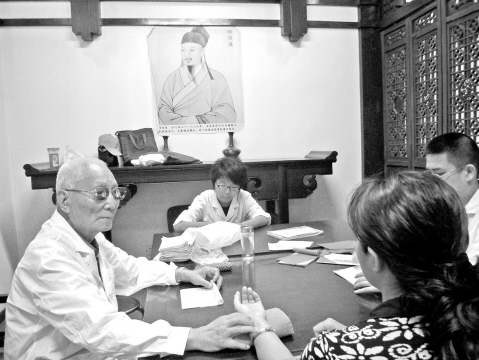 颜正华(左一)为患者看病、带教